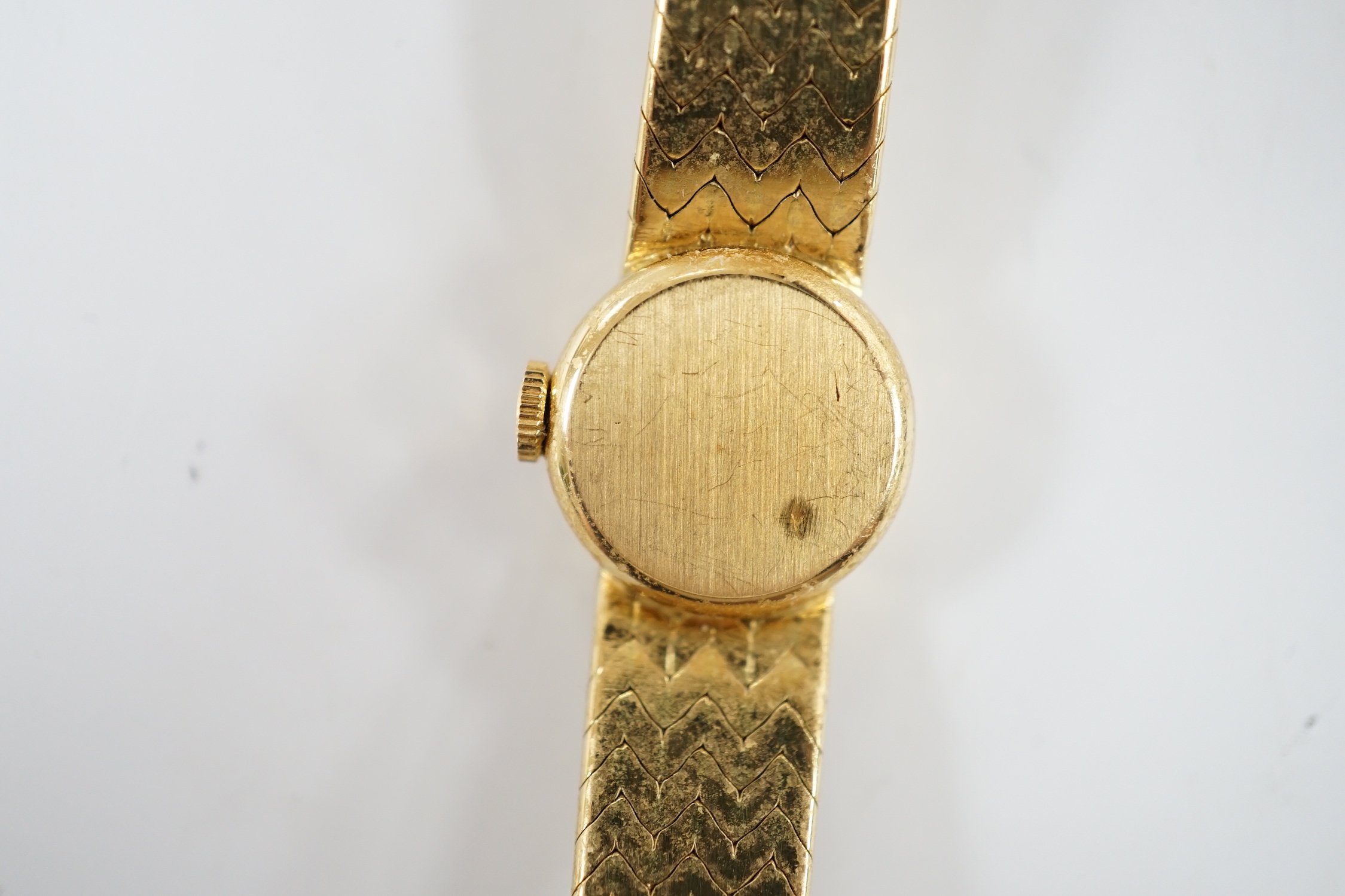 A lady's textured 750 yellow metal Rolex manual wind wrist watch, on integral bracelet, no box or papers, case diameter 15mm